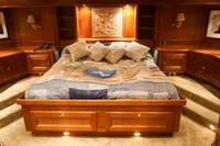 Luxurious wooden bedroom interior with a large bed, soft lighting, and elegant decor.