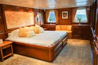Luxurious yacht bedroom with wood paneling, large bed, and elegant decor, 1966 Custom GLOBAL ENGINEERING.