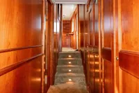 Wood-paneled hallway with carpeted stairs in a 1966 Custom Global Engineering model.