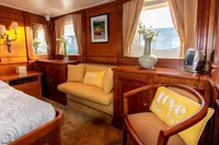 Luxurious 1966 custom yacht cabin with elegant wood paneling and cozy seating.