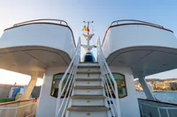 Staircase on a 1966 Custom GLOBAL ENGINEERING yacht, with ocean and cityscape background.