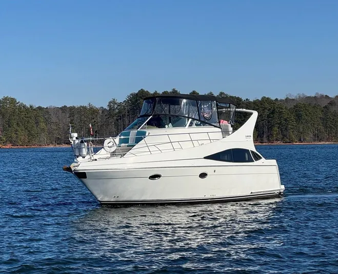  Yacht Photos Pics 2004 Carver 360 Mariner yacht cruising on a serene lake with forested shoreline.