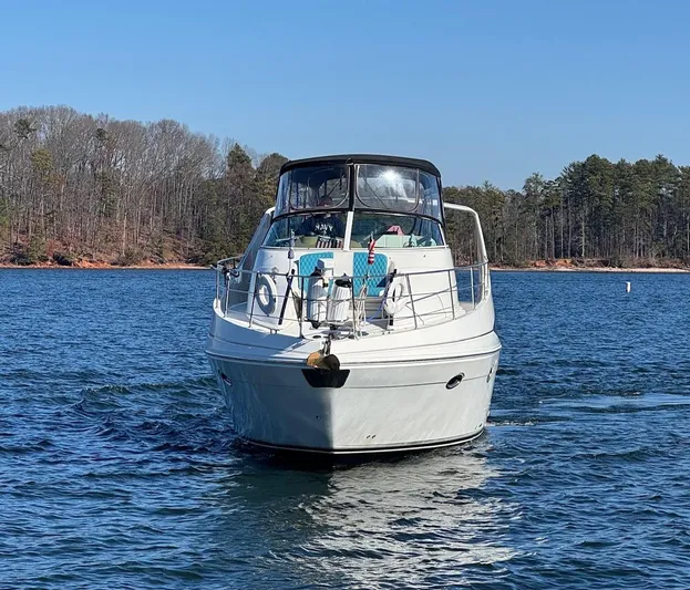  Yacht Photos Pics 2004 Carver 360 Mariner yacht cruising on a serene lake with forested shoreline.