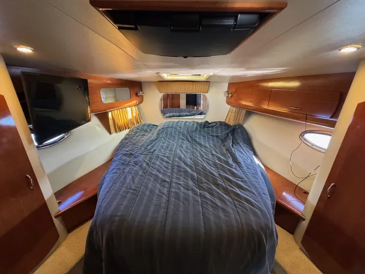  Yacht Photos Pics Interior cabin of 2004 Carver 360 Mariner with bed, TV, and wooden cabinets.