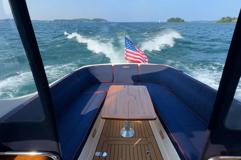  Yacht Photos Pics 2024 DaVinci 30HT boat interior with American flag, cruising on open water.
