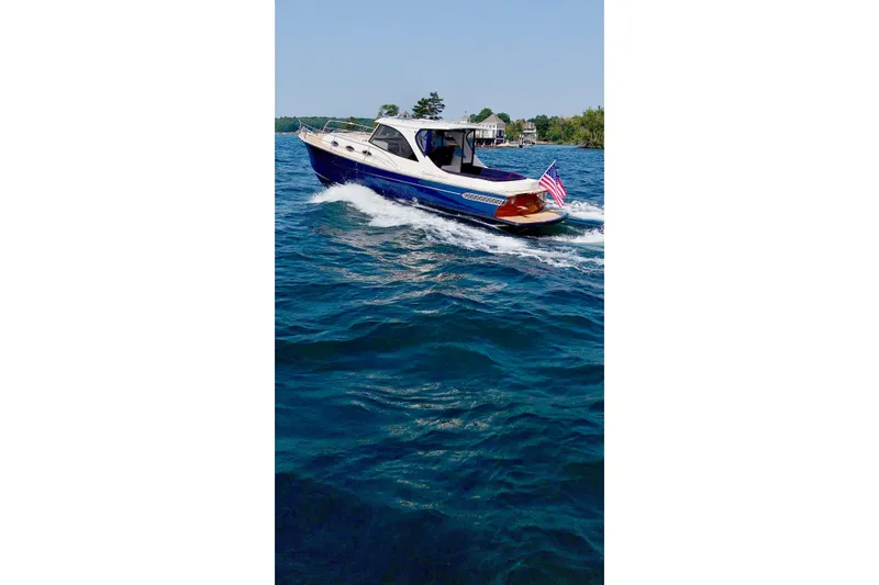  Yacht Photos Pics 2024 DaVinci 30HT boat cruising on blue water with American flag.