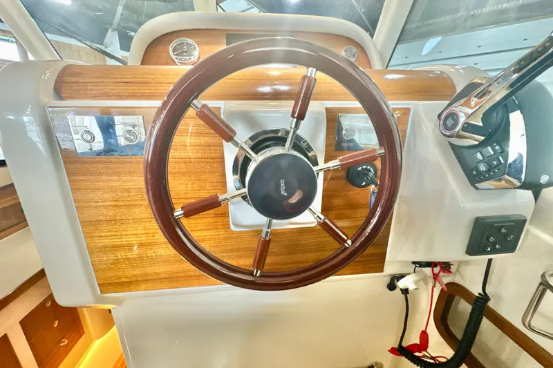  Yacht Photos Pics 2024 DaVinci 30HT boat steering wheel with wood accents and control panel.