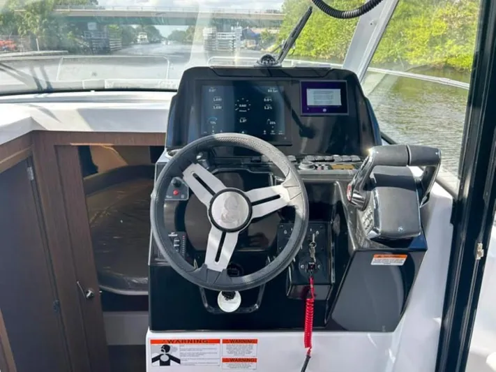  Yacht Photos Pics 2025 Beneteau Antares 9 helm with modern controls and navigation system.