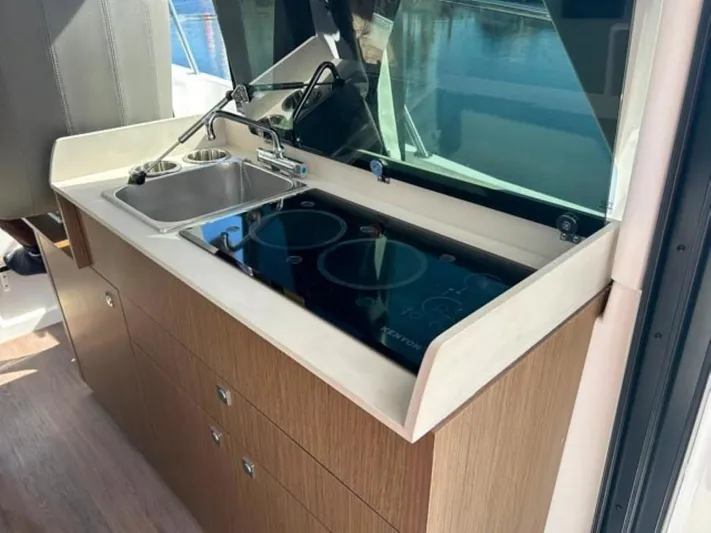  Yacht Photos Pics 2025 Beneteau Antares 9 yacht kitchen with sink and stove.