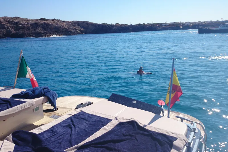 Double K Yacht Photos Pics Luxury yacht CNM Continental Tender 50, 2010, with flags, in scenic coastal waters.