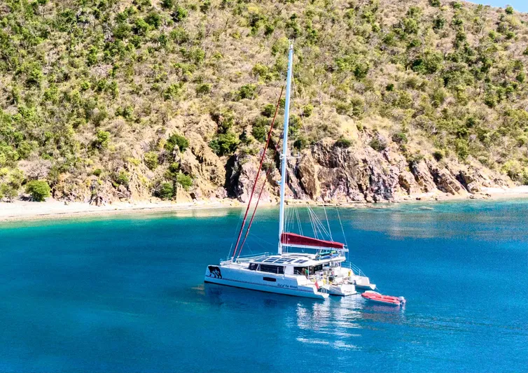 Out Of The Woods Yacht Photos Pics NEEL 51 Trimaran 2022 anchored in a tranquil bay.