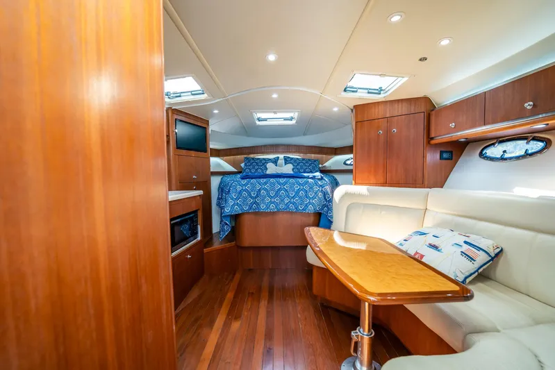 Maggie Yacht Photos Pics Luxurious interior of 2005 Tiara Yachts 3200 Open, featuring wood finishes and cozy seating.