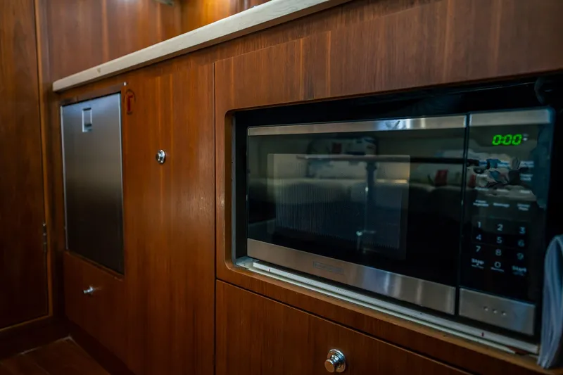 Maggie Yacht Photos Pics 2005 Tiara Yachts 3200 Open interior with microwave and wooden cabinetry.