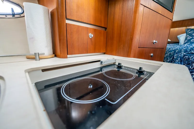 Maggie Yacht Photos Pics 2005 Tiara Yachts 3200 Open galley with stove and wooden cabinetry.