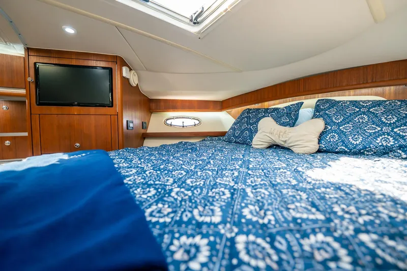 Maggie Yacht Photos Pics Luxurious cabin interior of 2005 Tiara Yachts 3200 Open with cozy bedding and TV.