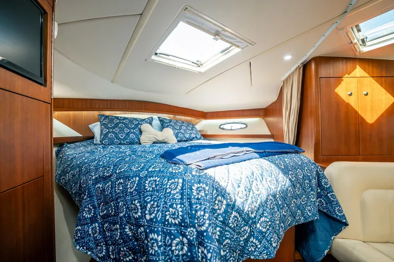 Maggie Yacht Photos Pics Luxurious cabin interior of 2005 Tiara Yachts 3200 Open with cozy bedding and wood finishes.