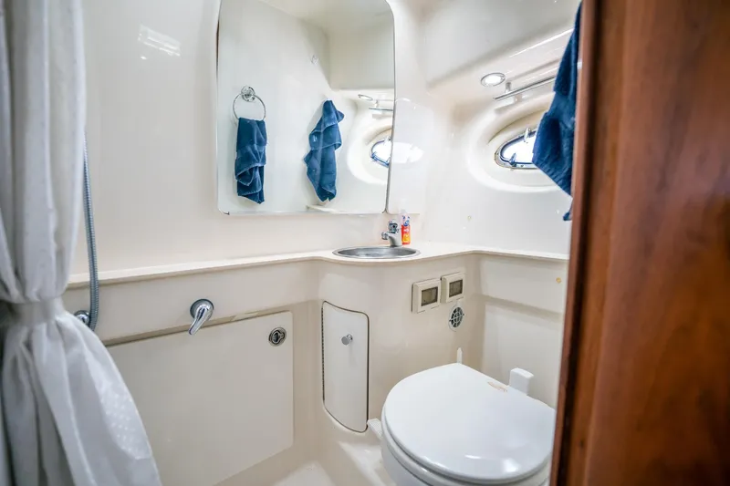 Maggie Yacht Photos Pics 2005 Tiara Yachts 3200 Open bathroom with sink, mirror, and porthole windows.