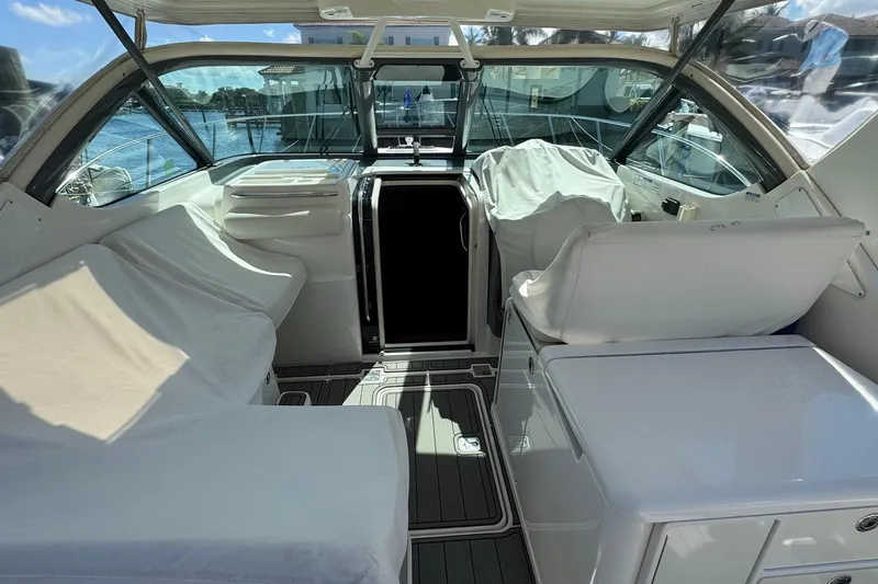 Maggie Yacht Photos Pics 2005 Tiara Yachts 3200 Open cockpit with covered seating and helm, docked by the water.