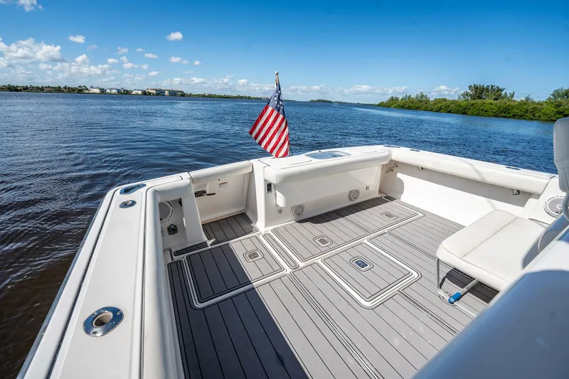 Maggie Yacht Photos Pics 2005 Tiara Yachts 3200 Open boat deck with American flag, on calm water.