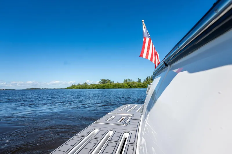 Maggie Yacht Photos Pics 2005 Tiara Yachts 3200 Open on water, American flag, clear blue sky.