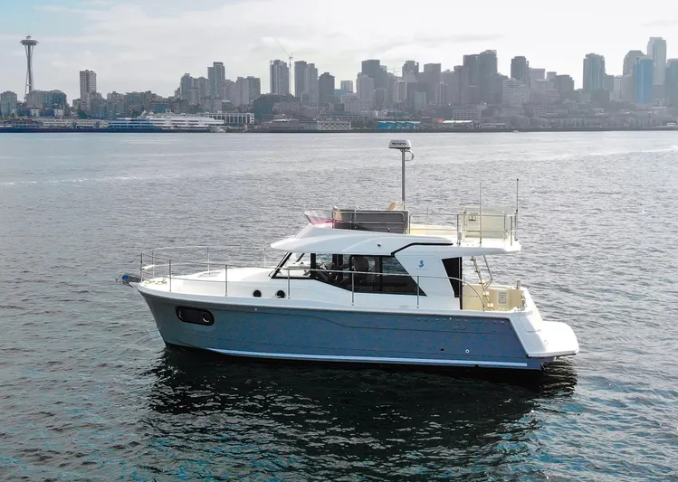 Everything Is Fine Yacht Photos Pics 2019 Beneteau Swift Trawler 30 cruising near city skyline and iconic tower.