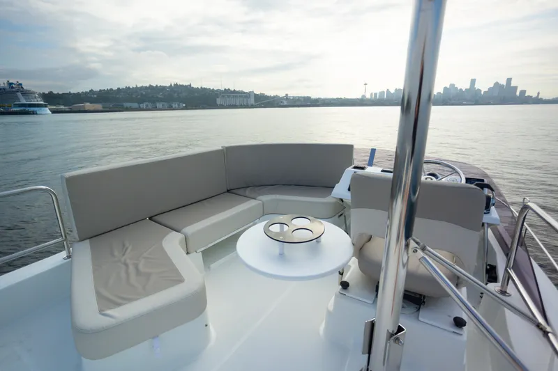 Everything Is Fine Yacht Photos Pics 2019 Beneteau Swift Trawler 30 deck with seating, table, and scenic waterfront view.