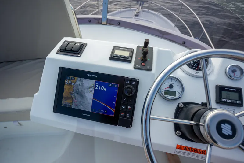 Everything Is Fine Yacht Photos Pics Control panel of 2019 Beneteau Swift Trawler 30 with navigation display and steering wheel.