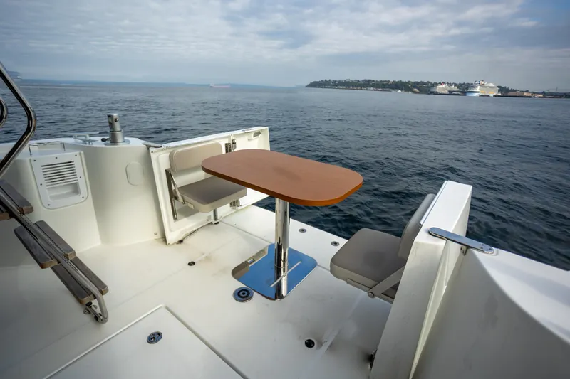 Everything Is Fine Yacht Photos Pics 2019 Beneteau Swift Trawler 30 deck with table and seating, ocean view.