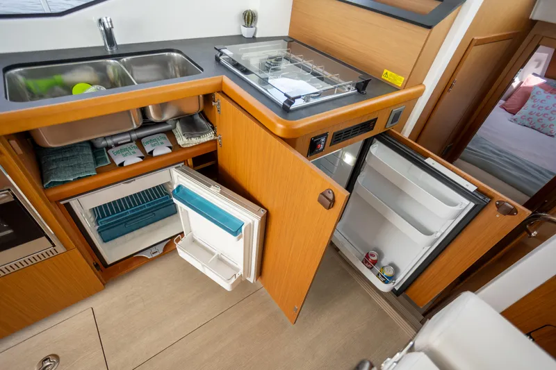 Everything Is Fine Yacht Photos Pics 2019 Beneteau Swift Trawler 30 kitchen with open fridge, sink, and storage.