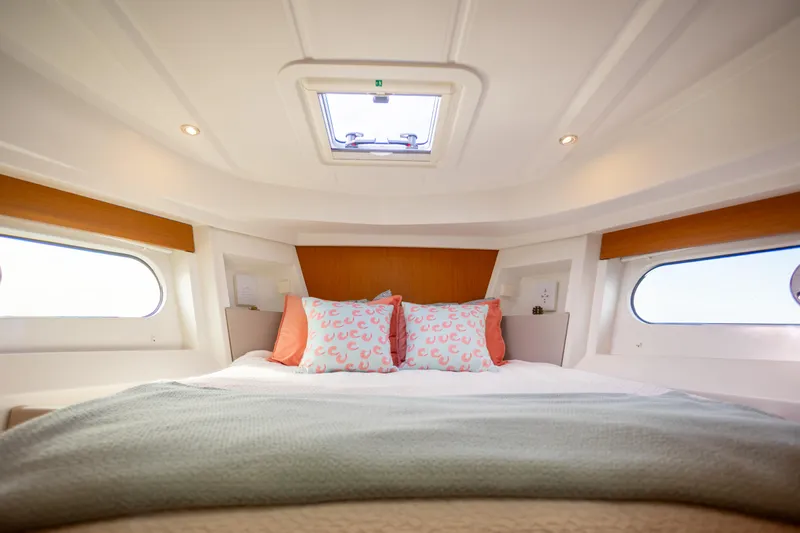 Everything Is Fine Yacht Photos Pics Cozy bedroom interior of 2019 Beneteau Swift Trawler 30 with skylight and decorative pillows.