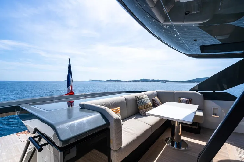  Yacht Photos Pics Luxurious 2025 Bluegame BGX 63 yacht deck with seating, table, and ocean view.