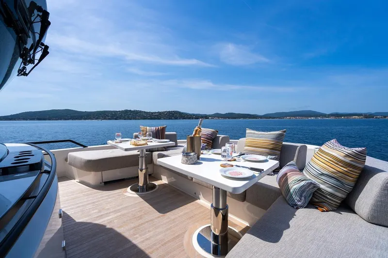  Yacht Photos Pics Luxurious 2025 Bluegame BGX 63 yacht deck with elegant dining setup and scenic ocean view.