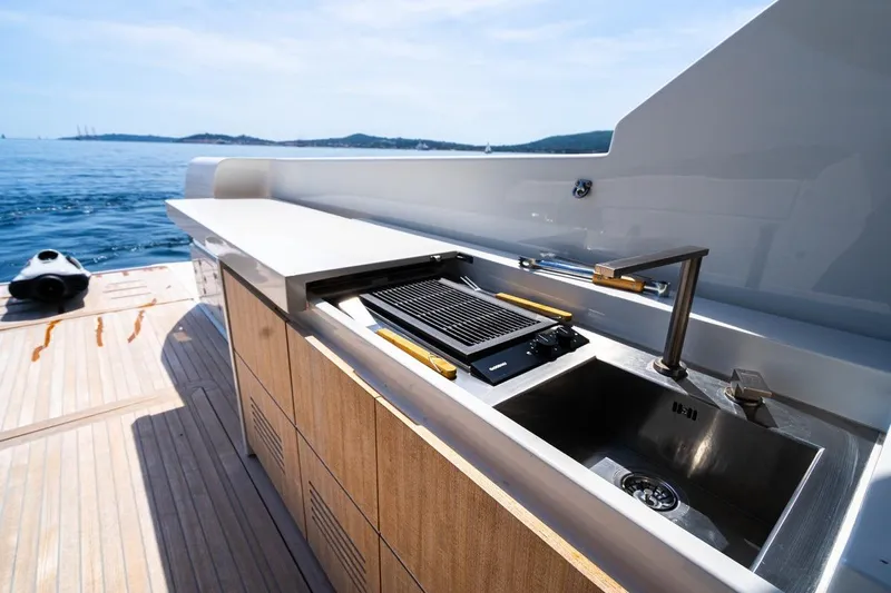  Yacht Photos Pics Outdoor kitchen on 2025 Bluegame BGX 63 yacht with grill and sink, ocean view.