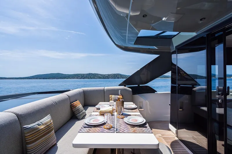  Yacht Photos Pics Luxurious 2025 Bluegame BGX 63 yacht with elegant outdoor dining area and scenic ocean view.