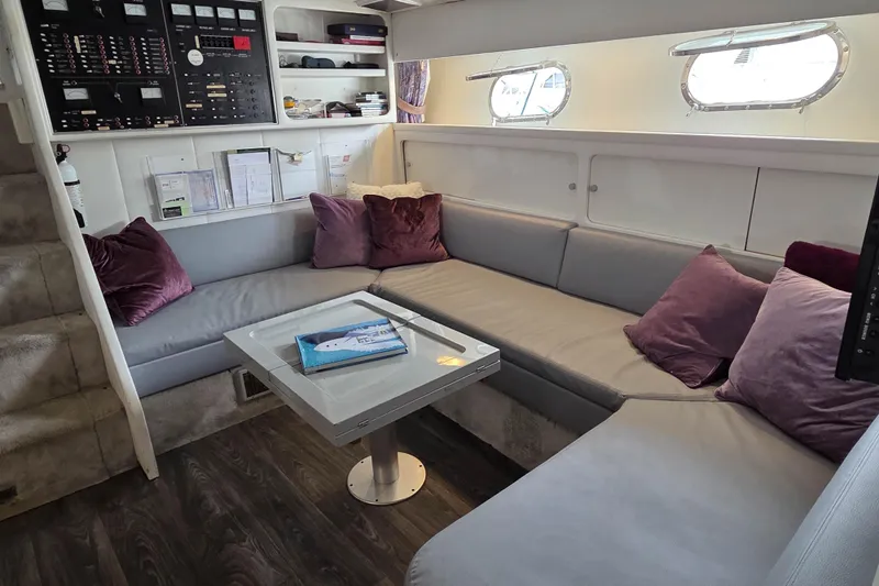 Halcyon Yacht Photos Pics Interior of 1984 MAGNUM MARINE 53 yacht with cozy seating and control panel.