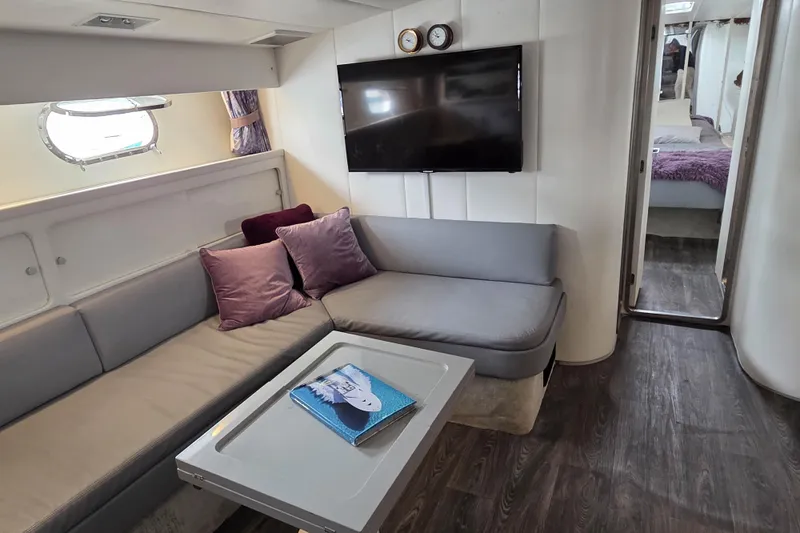 Halcyon Yacht Photos Pics Interior of 1984 MAGNUM MARINE 53 yacht with modern seating, TV, and elegant decor.