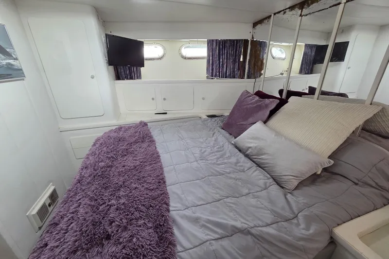 Halcyon Yacht Photos Pics Cozy bedroom in 1984 MAGNUM MARINE 53 yacht with plush bedding and modern decor.
