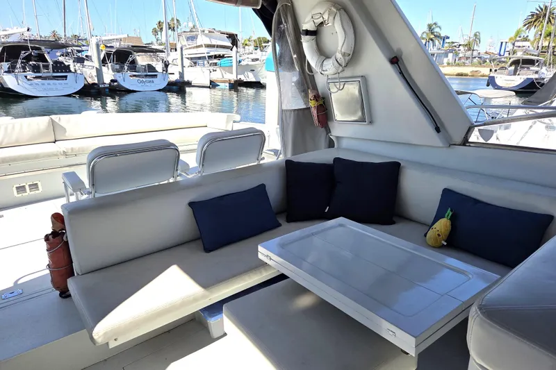 Halcyon Yacht Photos Pics Luxurious seating area on a 1984 Magnum Marine 53 yacht, docked at a marina.