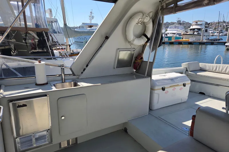 Halcyon Yacht Photos Pics 1984 Magnum Marine 53 yacht interior with sink, cooler, and marina view.