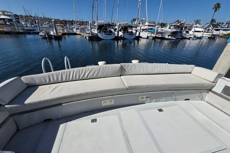 Halcyon Yacht Photos Pics 1984 Magnum Marine 53 yacht with spacious seating at a marina.