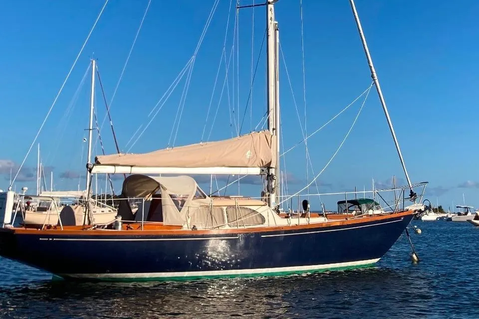 1967 Columbia Constellation sailboat on calm water under clear blue sky.