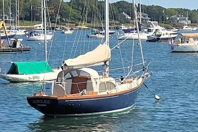 1967 Columbia Constellation sailboat named "Jubilee" anchored in a scenic marina.