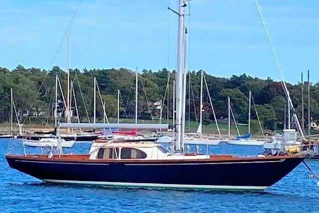 1967 Columbia Constellation sailboat anchored in a scenic harbor with other boats.