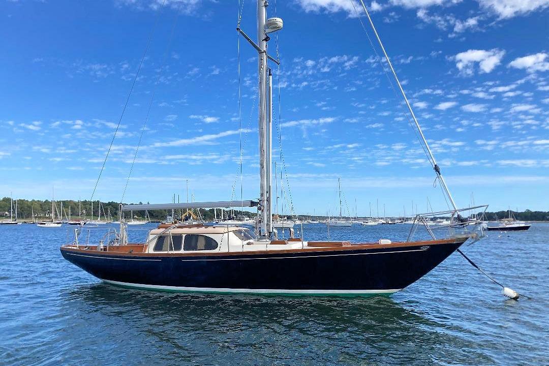 1967 Columbia Constellation sailboat on calm water under a clear blue sky.