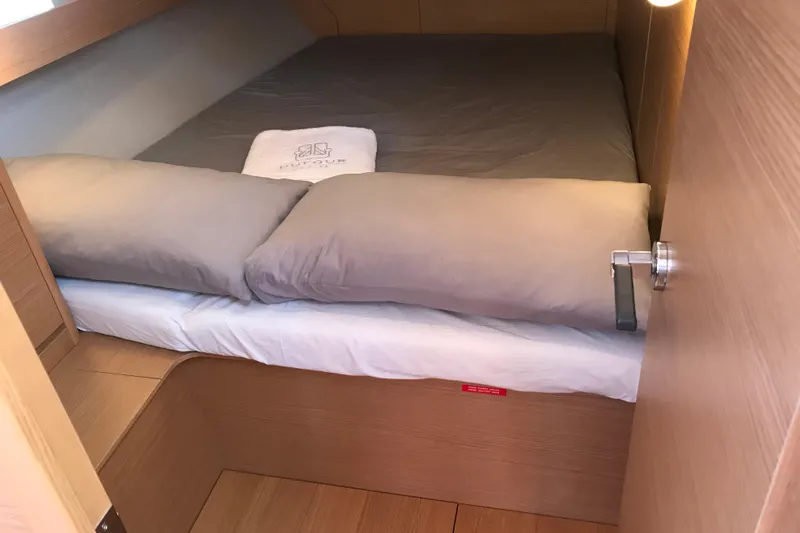  Yacht Photos Pics Cozy cabin bed in 2019 Dufour 460 Grand Large yacht, featuring soft pillows and wooden interior.