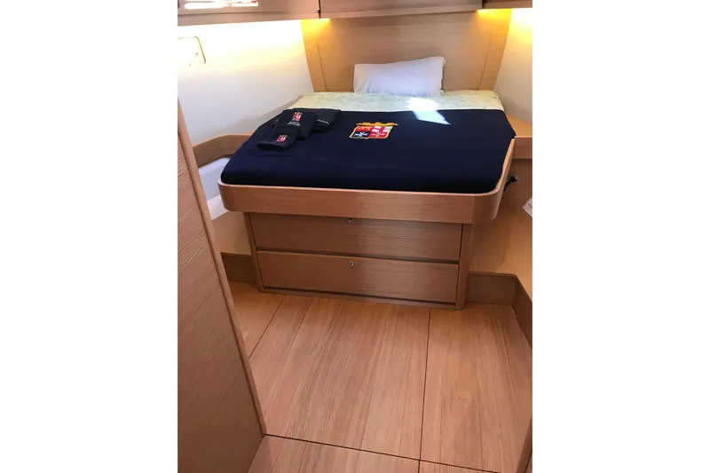  Yacht Photos Pics 2019 Dufour 460 Grand Large yacht cabin with wooden interior and cozy bed.
