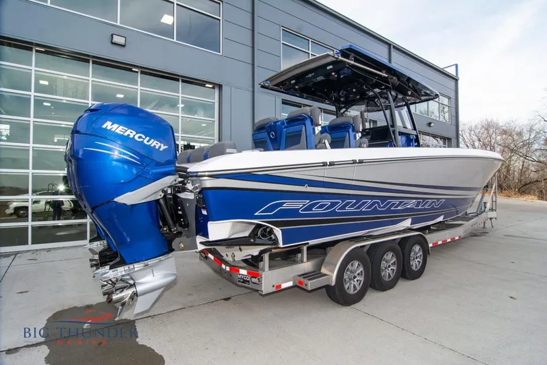  Yacht Photos Pics 2022 Fountain 38 SC boat with Mercury engines on a trailer outside a modern building.