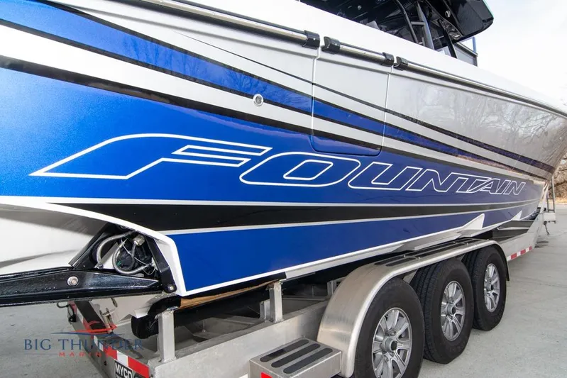  Yacht Photos Pics 2022 Fountain 38 SC boat on trailer, featuring sleek blue and white design.