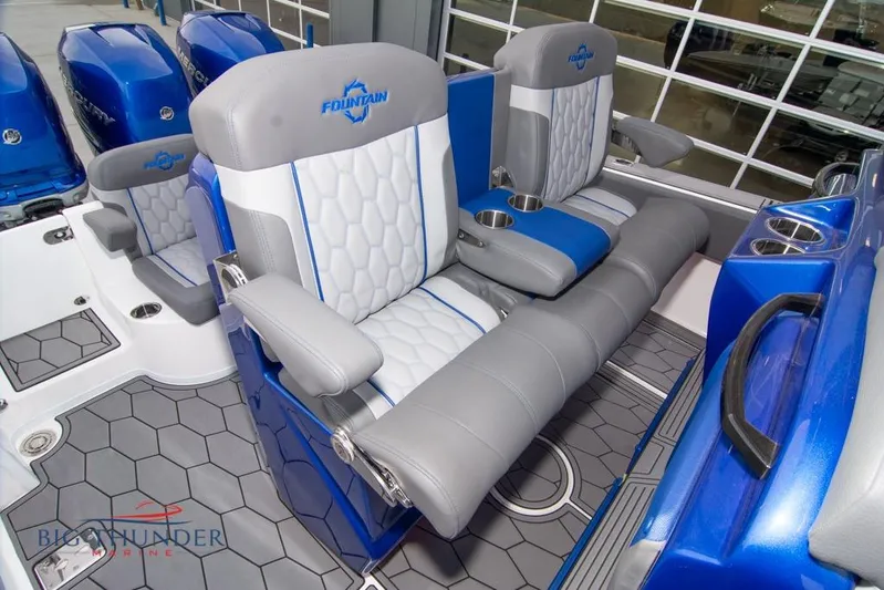  Yacht Photos Pics 2022 Fountain 38 SC boat interior with blue and gray seating, cup holders, and hexagonal flooring.