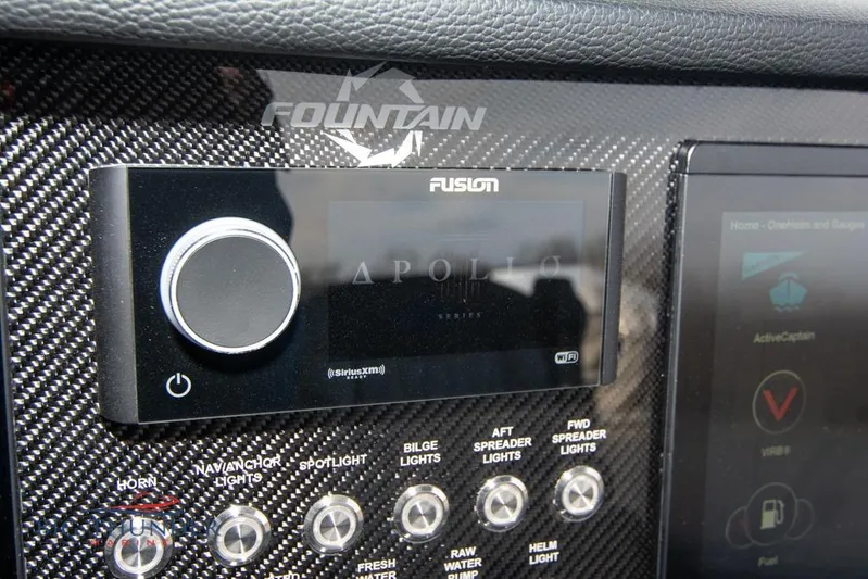  Yacht Photos Pics Control panel of 2022 Fountain 38 SC boat with Fusion audio system and carbon fiber finish.